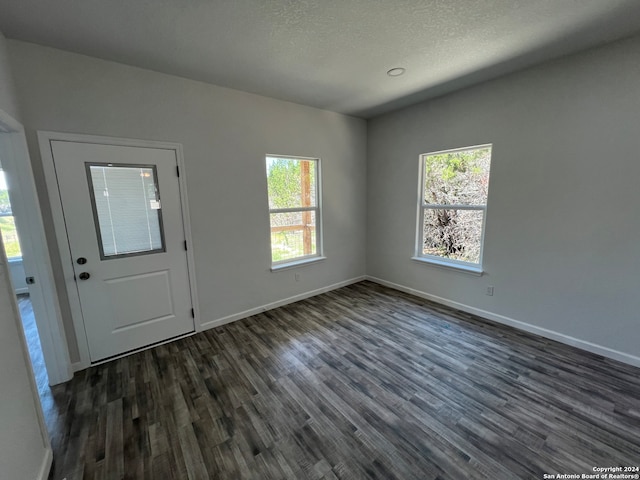 entrance foyer with a textured ceiling and dark hardwood / wood-style floors