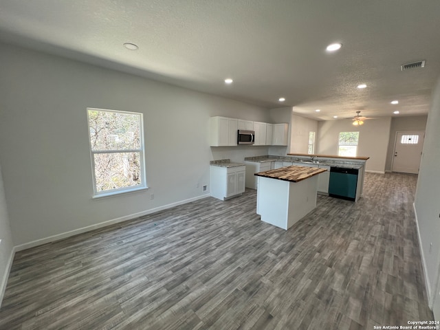 kitchen with a kitchen island, hardwood / wood-style flooring, white cabinetry, and a wealth of natural light