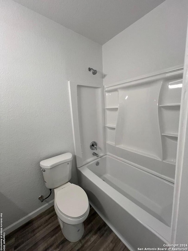 bathroom with bathtub / shower combination, wood-type flooring, and toilet