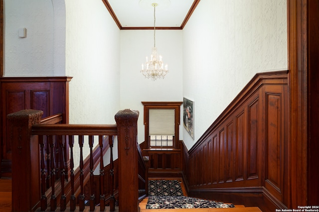 stairs with a notable chandelier and ornamental molding