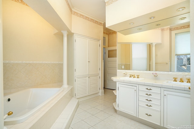 bathroom featuring decorative columns, tiled tub, vanity, and tile patterned flooring