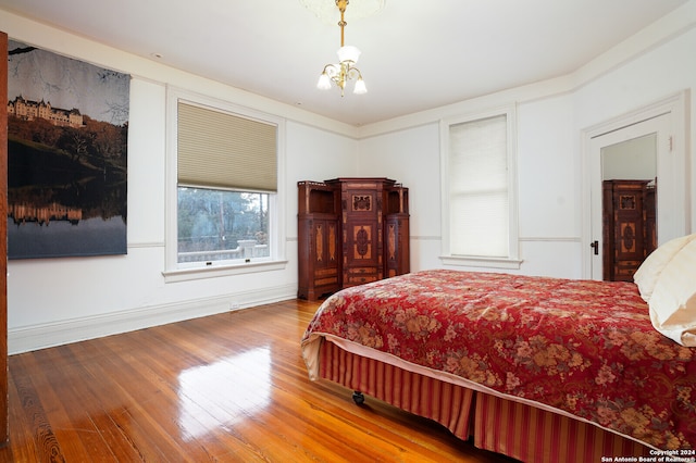 bedroom featuring an inviting chandelier and hardwood / wood-style floors