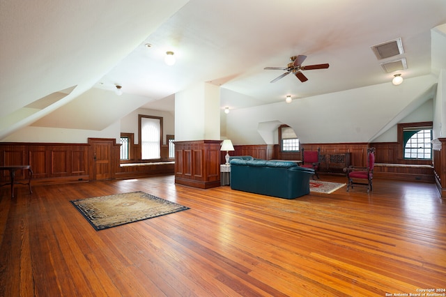 additional living space featuring ceiling fan, lofted ceiling, wood walls, and dark wood-type flooring