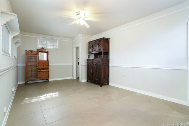 tiled spare room with crown molding and ceiling fan