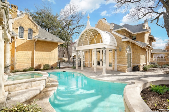 exterior space featuring a patio, an in ground hot tub, and french doors