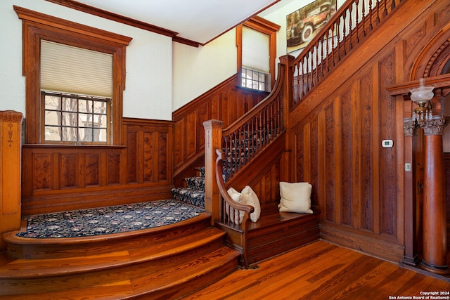 stairway with crown molding and hardwood / wood-style floors