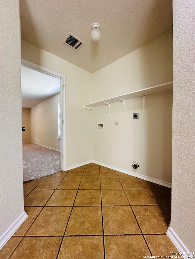 laundry room featuring washer hookup, hookup for an electric dryer, gas dryer hookup, a textured ceiling, and tile patterned flooring