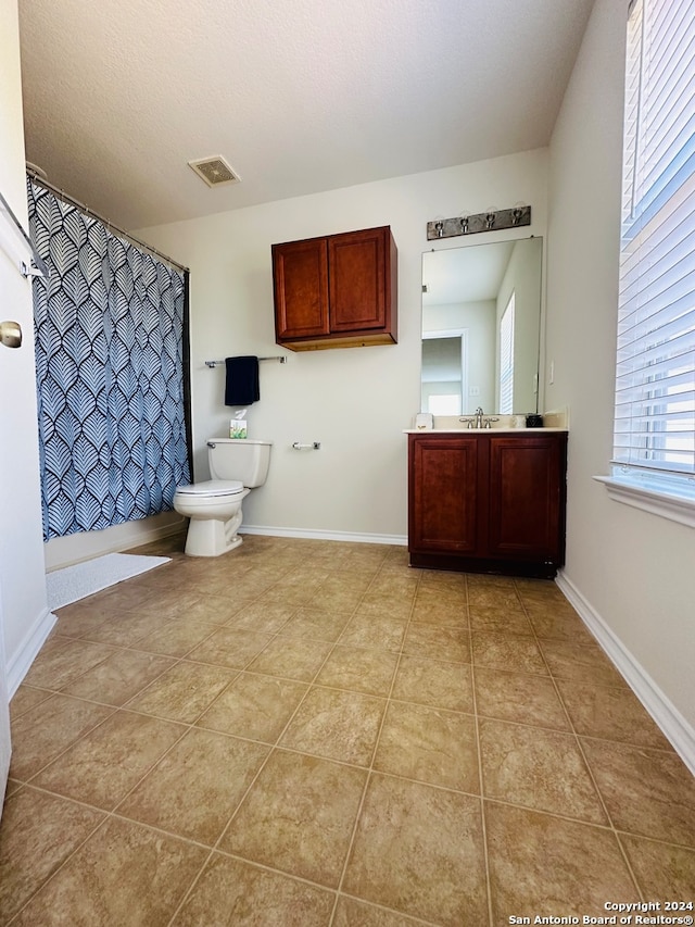 bathroom with curtained shower, vanity, toilet, and tile patterned floors