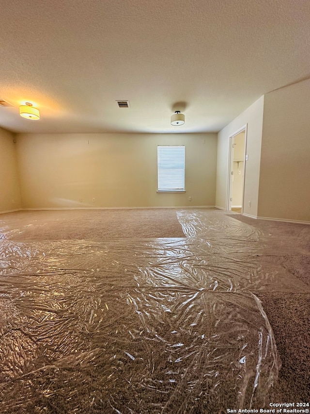 unfurnished room featuring a textured ceiling