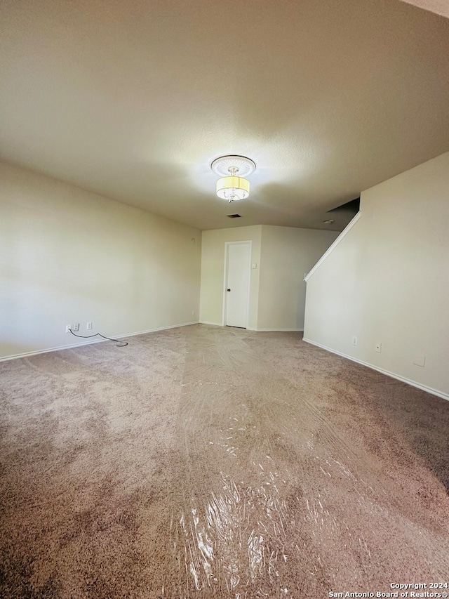 carpeted spare room featuring a textured ceiling