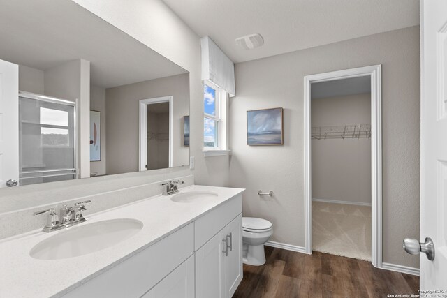 bathroom featuring wood-type flooring, vanity, and toilet