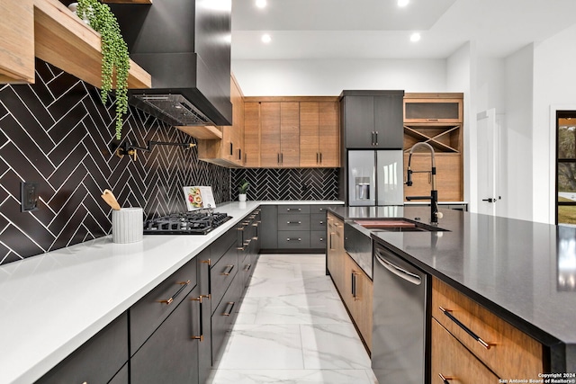 kitchen with stainless steel appliances, backsplash, wall chimney range hood, and sink