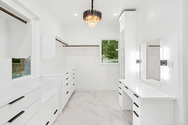 walk in closet featuring an inviting chandelier