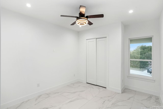 unfurnished bedroom with ceiling fan and a closet