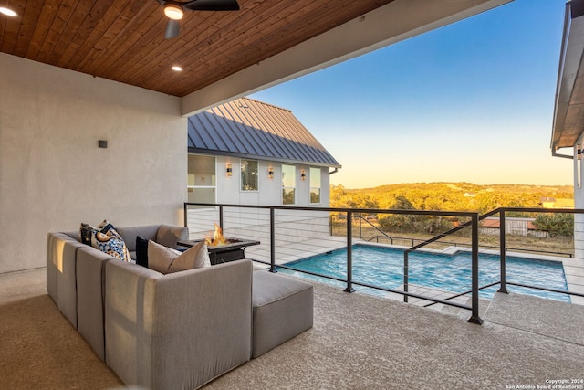 pool at dusk featuring an outdoor living space and a patio