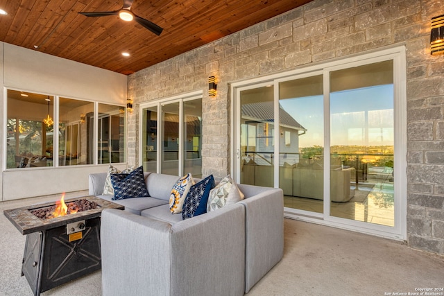 patio terrace at dusk featuring an outdoor living space with a fire pit and ceiling fan