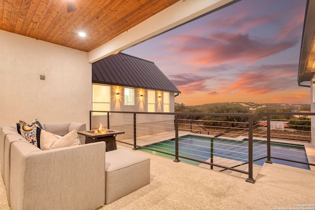 pool at dusk featuring a patio and an outdoor fire pit