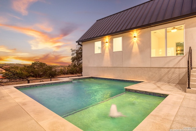 pool at dusk featuring a patio