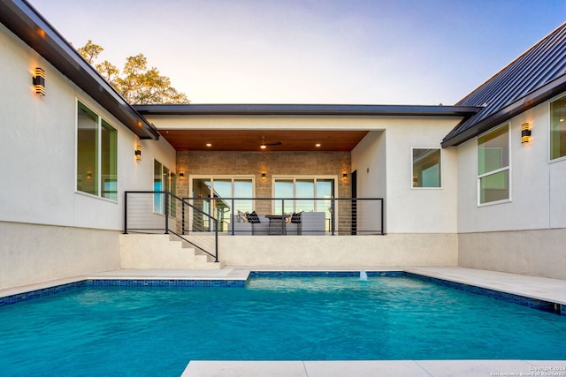 pool at dusk featuring a patio