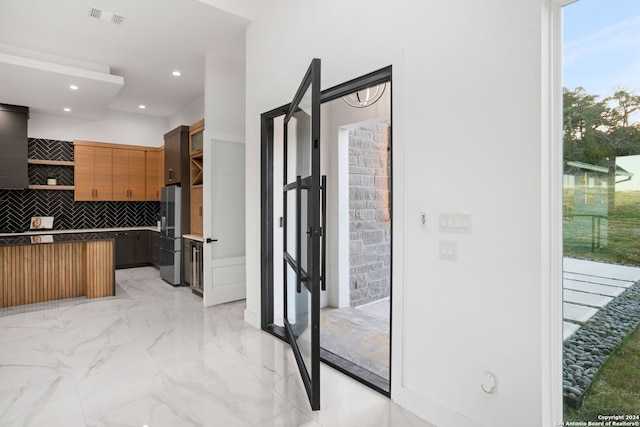 kitchen featuring backsplash and stainless steel fridge