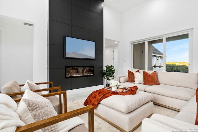 living room featuring a high ceiling and a fireplace