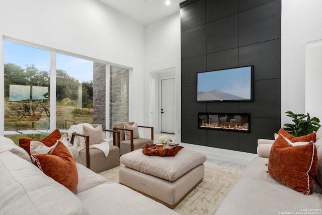 living room featuring a high ceiling and a fireplace