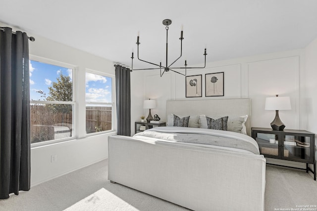 bedroom featuring light colored carpet and a notable chandelier