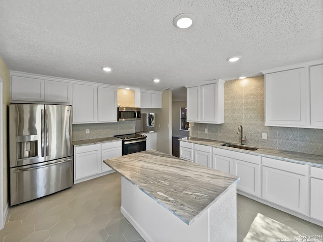 kitchen featuring white cabinetry, a textured ceiling, appliances with stainless steel finishes, and sink