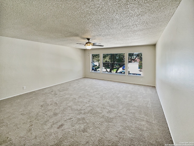 empty room featuring a textured ceiling, carpet flooring, and ceiling fan