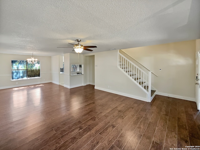 unfurnished living room featuring a textured ceiling, ceiling fan with notable chandelier, and dark hardwood / wood-style flooring