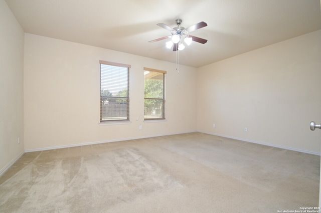 empty room with ceiling fan and light carpet