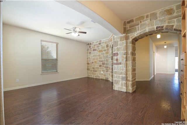 unfurnished living room featuring dark hardwood / wood-style flooring and ceiling fan