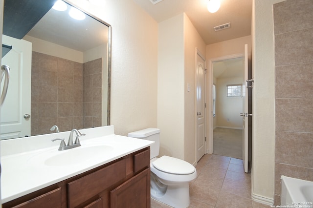 bathroom featuring a washtub, tile patterned flooring, vanity, and toilet