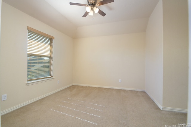 empty room with ceiling fan, light colored carpet, and lofted ceiling