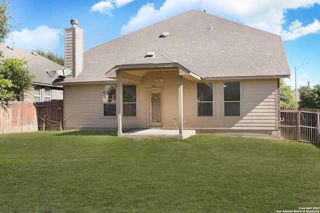 rear view of property with a lawn and a patio area