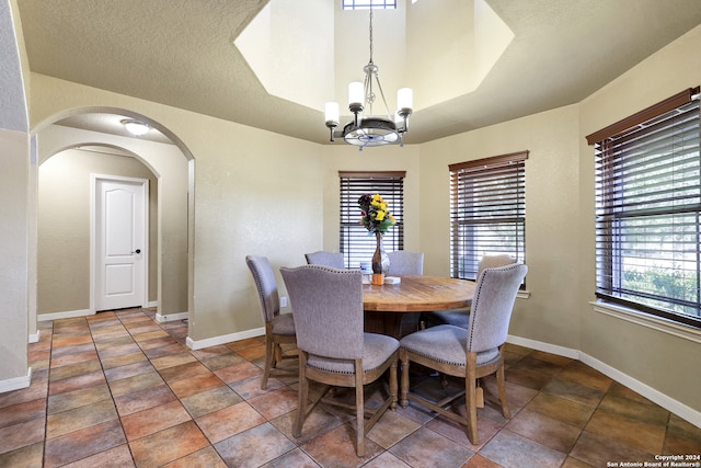 dining space with an inviting chandelier, a wealth of natural light, and a textured ceiling