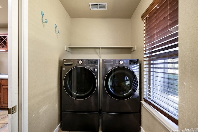 laundry room with separate washer and dryer, tile patterned flooring, and a healthy amount of sunlight