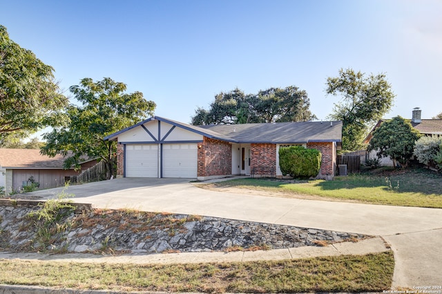 single story home with cooling unit, a front yard, and a garage