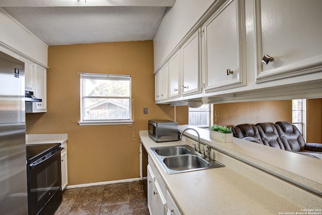 kitchen featuring stainless steel appliances, white cabinets, a textured ceiling, and sink