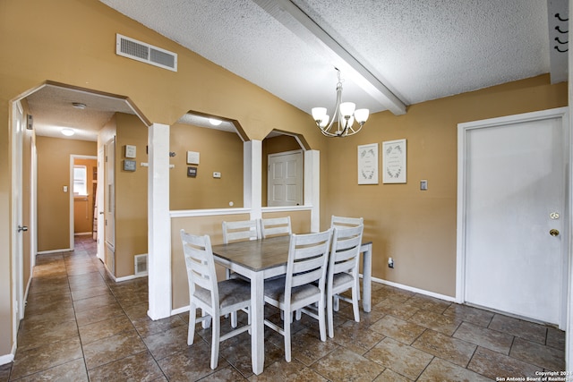 dining area with a textured ceiling, lofted ceiling with beams, and an inviting chandelier