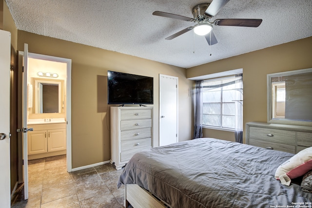 bedroom with a textured ceiling, connected bathroom, and ceiling fan