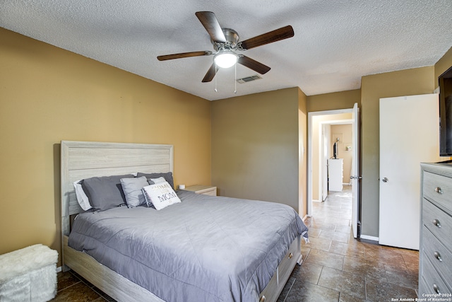 bedroom with ceiling fan and a textured ceiling