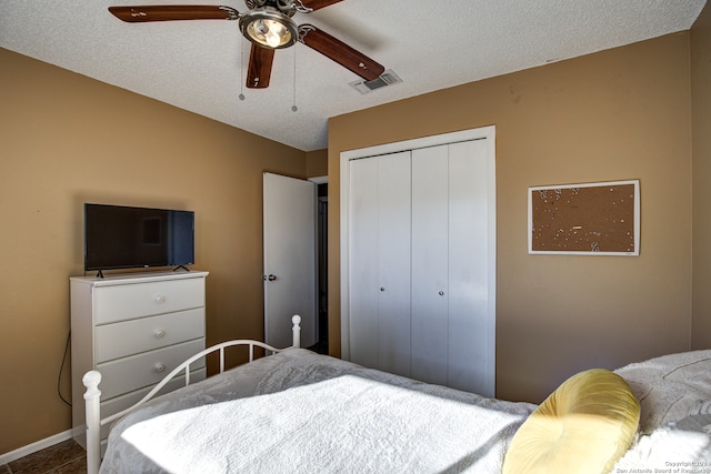 bedroom featuring a textured ceiling, ceiling fan, and a closet