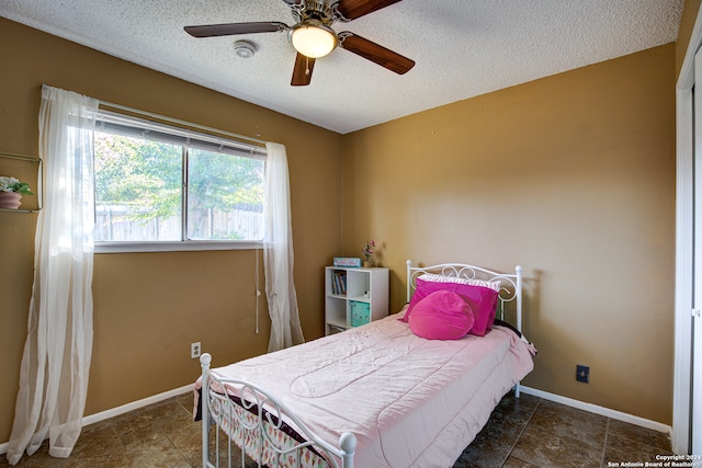 bedroom with a textured ceiling and ceiling fan