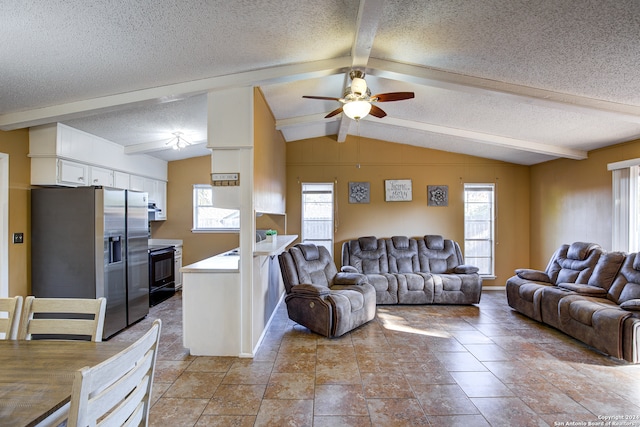 living room with ceiling fan, vaulted ceiling with beams, a textured ceiling, and a wealth of natural light