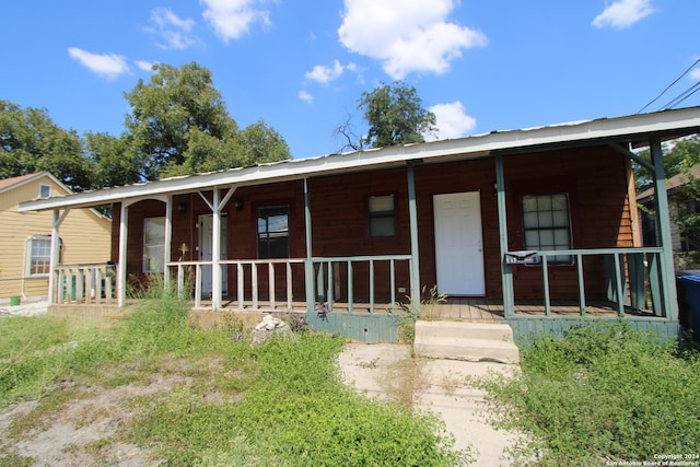 rear view of property with covered porch