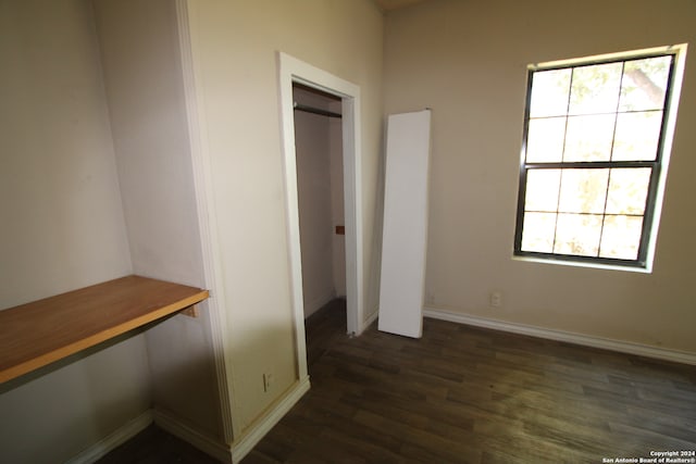 unfurnished bedroom featuring a closet and dark wood-type flooring