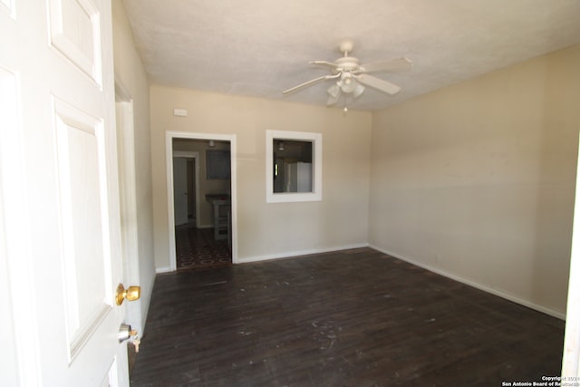 empty room featuring ceiling fan and dark hardwood / wood-style flooring