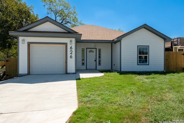 ranch-style house featuring a garage and a front lawn