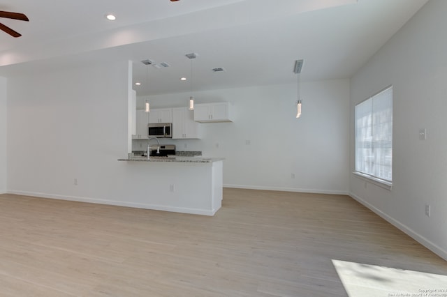 unfurnished living room featuring ceiling fan and light hardwood / wood-style flooring